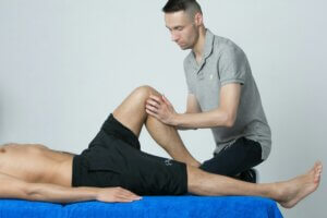 male physiotherapist helping client